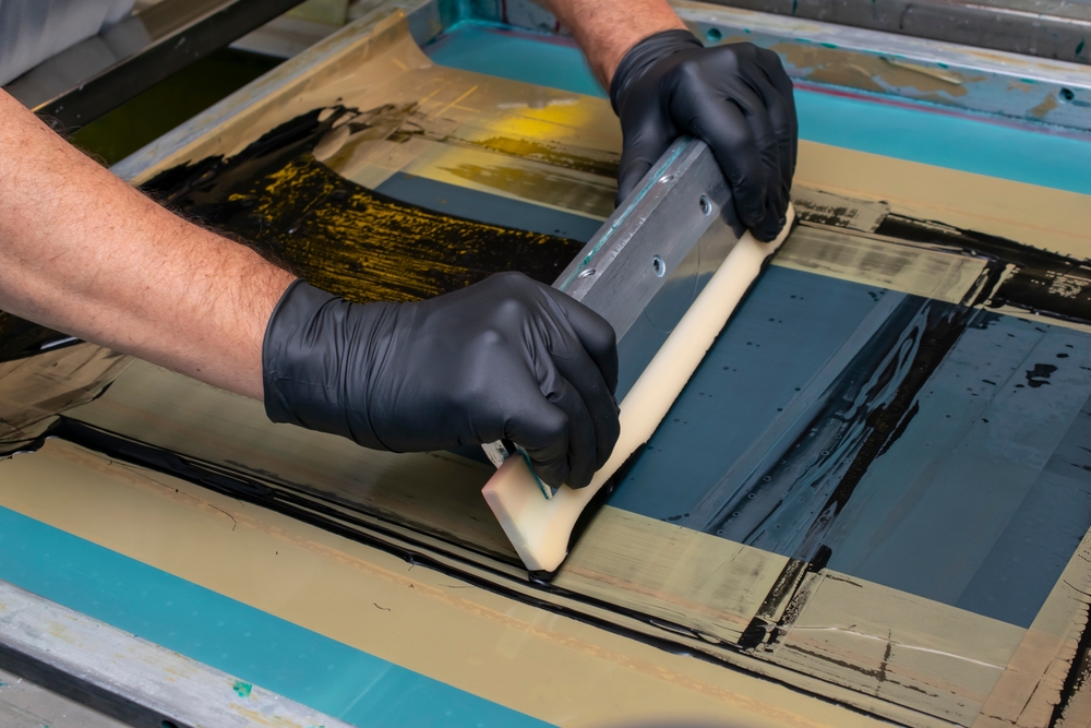 Hand,made,screen,printing,,squeezing,the,paint,with,a,squeegee